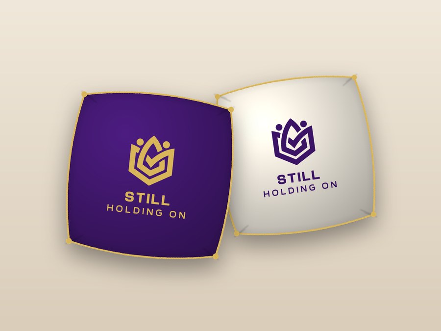 Purple and ivory throw pillows with the Still Holding On logo